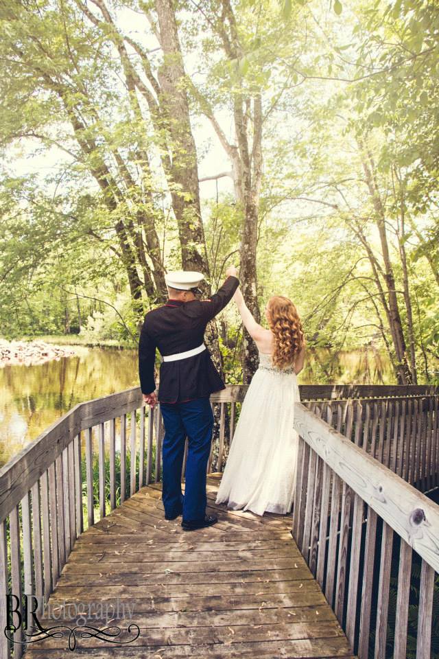 Couple posing for wedding photos on a wooden boardwalk surrounded by trees