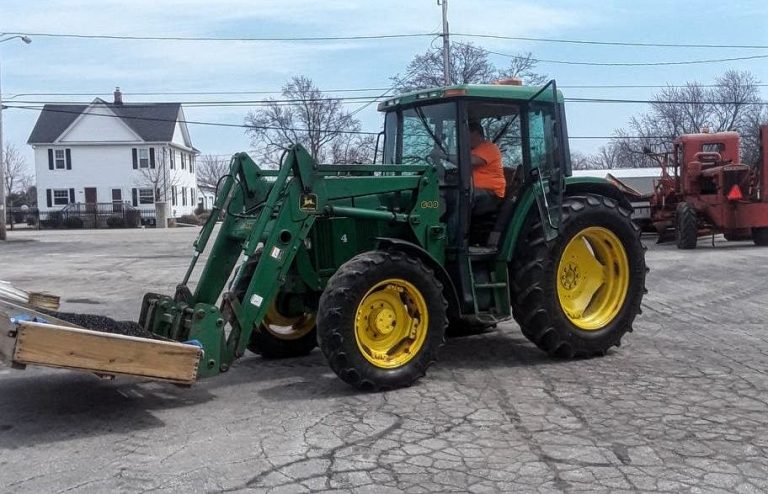 Green utility tractor equipped with a front loader attachment